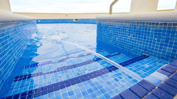 A swimming pool with blue mosaic tiles and a clear view of the sky. - Aiguadolç - Alojamientos MarCalma (Tarragona)