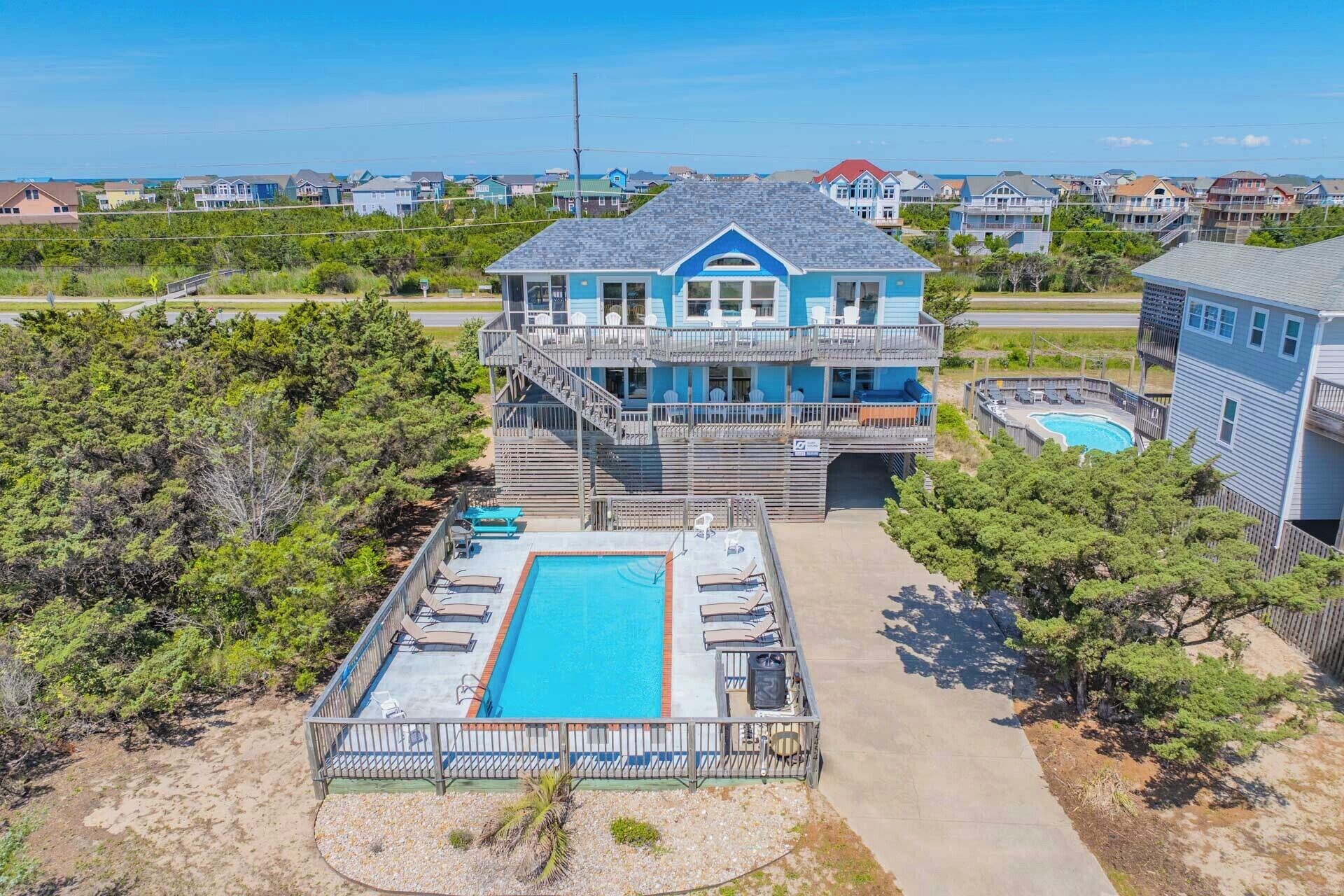 A multi-story building with a pool and outdoor seating.