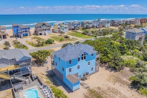 A coastal residential area with houses, a swimming pool, and a view of the ocean. - Semi-Oceanfront Home with Private Pool, Hot Tub, Game Room, Nearby Beach Access (Avon)