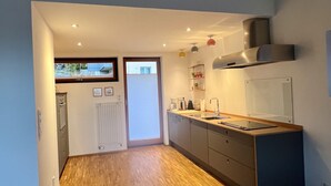 Una cocina moderna con suelo de madera, una isla integrada y un ventanal grande.