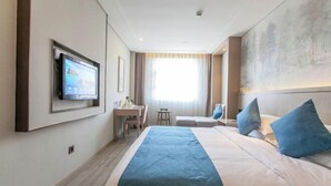 A hotel room with a bed, a desk, a chair, a television, and a large window. - Jiasheng International Hotel (Jiayu)