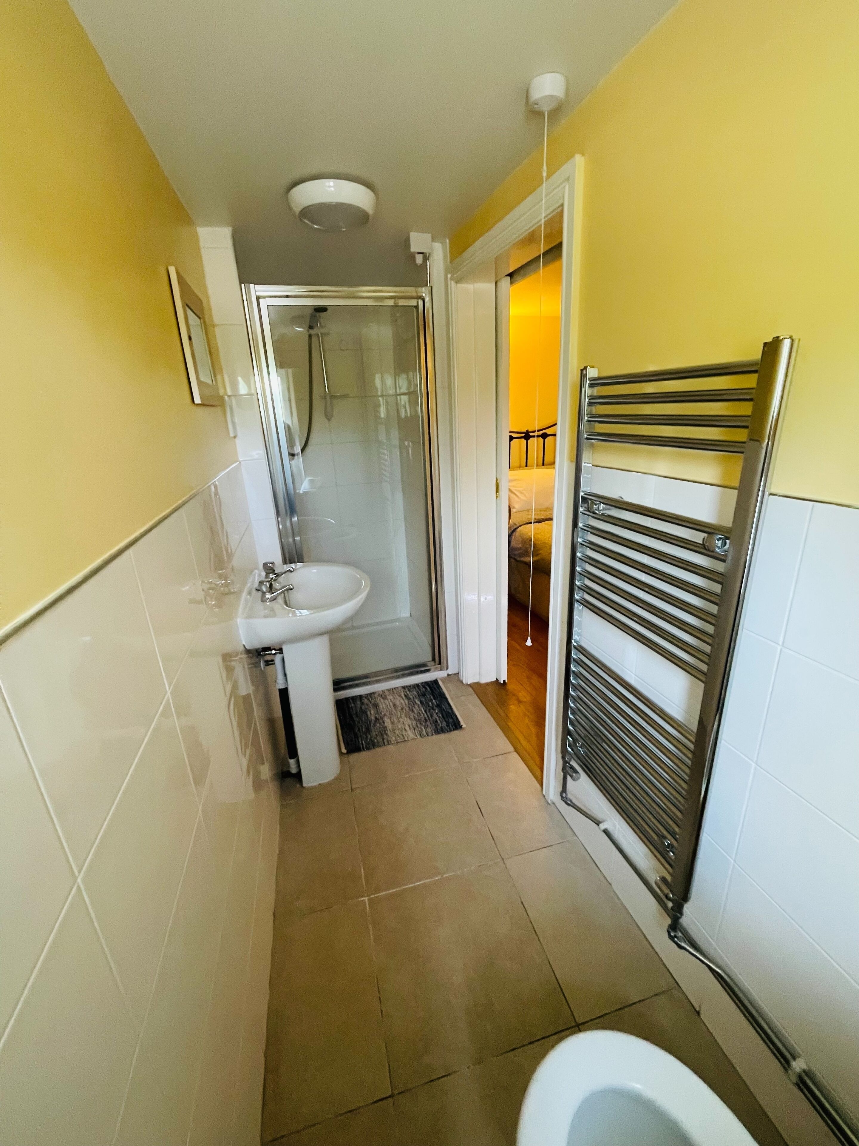 Un baño pequeño y funcional con ducha, lavabo e inodoro.