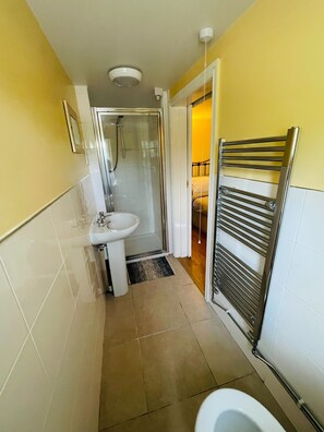 A compact bathroom with a shower, sink, and toilet. - The Boat Inn Hayton (Retford)