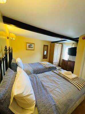 A room with two beds, a wooden wardrobe, a television, and a framed picture on the wall. - The Boat Inn Hayton (Retford)