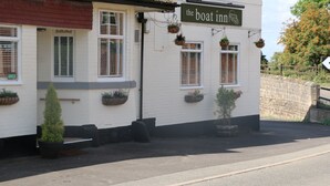 Un edificio blanco con un letrero que dice "the boat inn".