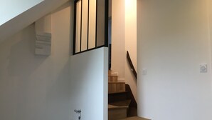 A staircase with wooden steps and a black railing.