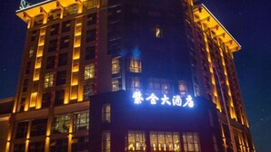 Un edificio de hotel con señalización iluminada durante la noche.