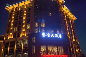 Un edificio de varios pisos con señalización iluminada, amplias ventanas y una entrada destacada.