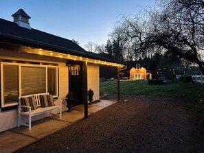 A house with a porch, a bench, and string lights. - Cozy Cottage on Applegate River Micro-Farm at Vineyards.15 Min to Jacksonville (Jacksonville)