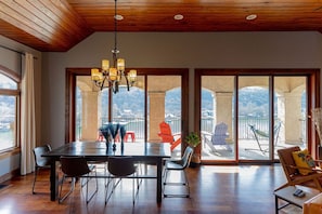 Relax in this spacious room with a high ceiling, featuring a dining table and comfortable seating area.