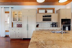 A kitchen with white cabinetry, a marble countertop, and a built-in oven. - Spacious Luxury Retreat: Ideal for Groups, Families & Couples Seeking Serenity (Austin)