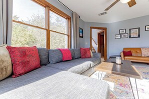 A modern living room with a grey sectional sofa, a wooden coffee table, and a patterned rug. - Spacious Luxury Retreat: Ideal for Groups, Families & Couples Seeking Serenity (Austin)