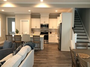 A modern kitchen with white cabinets, stainless steel appliances, and a central island.