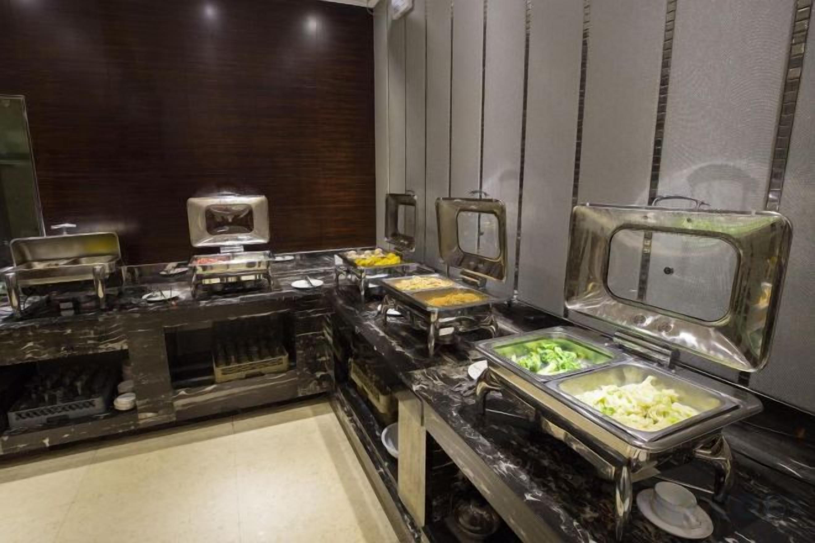 A buffet setup with various food stations, including a salad bar and a hot food station.