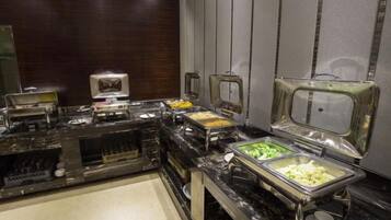 A buffet setup with various food stations, including a salad bar and a hot food station.