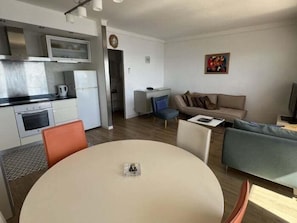 A compact living space with a kitchenette, a dining area, and a sofa.