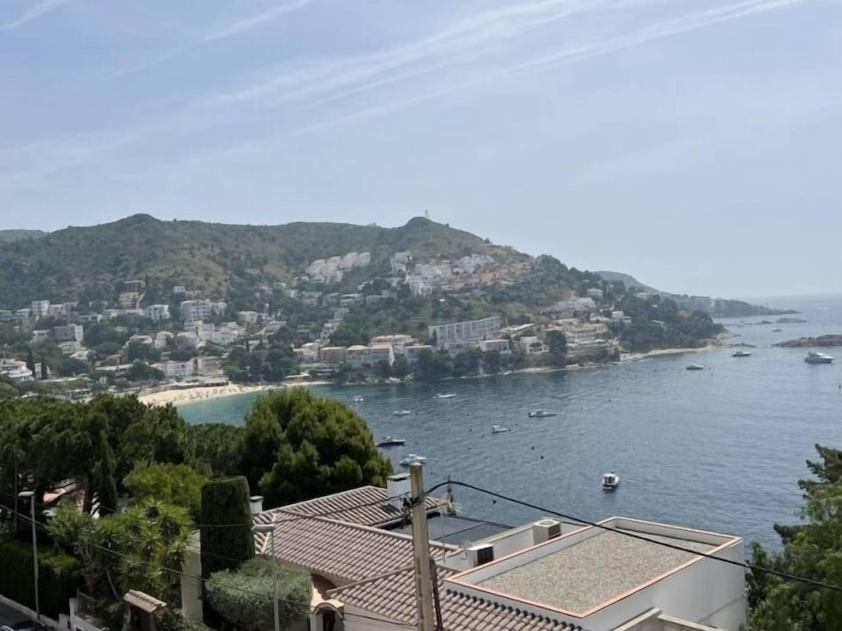 A coastal town with buildings on a hillside overlooking the sea.