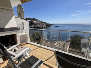 Un balcón con vista al mar y a un pueblo.