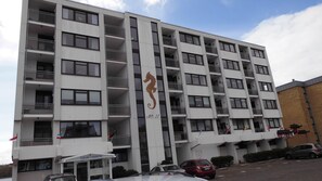 A multi-story building with balconies, a seahorse logo, and the name 'AQUA MARINA' on the ground floor.