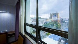 A room with a large window overlooking a cityscape.