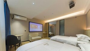 A hotel room with two beds, a desk, a chair, a TV screen, and a mirror.