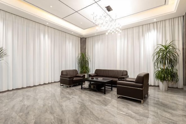 Una sala de estar moderna con un sofá modular, una mesa de centro y dos plantas en macetas.