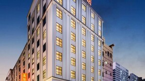 A multi-story hotel building with a prominent sign at the top.