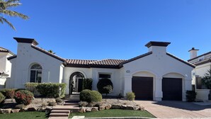 A two-story house with a tiled roof, a front entrance with a door, and a garage. - Southshore single story Tuscany style home for rent! (Henderson)
