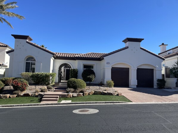 A two-story house with a tiled roof, a front entrance with a door, and a garage.