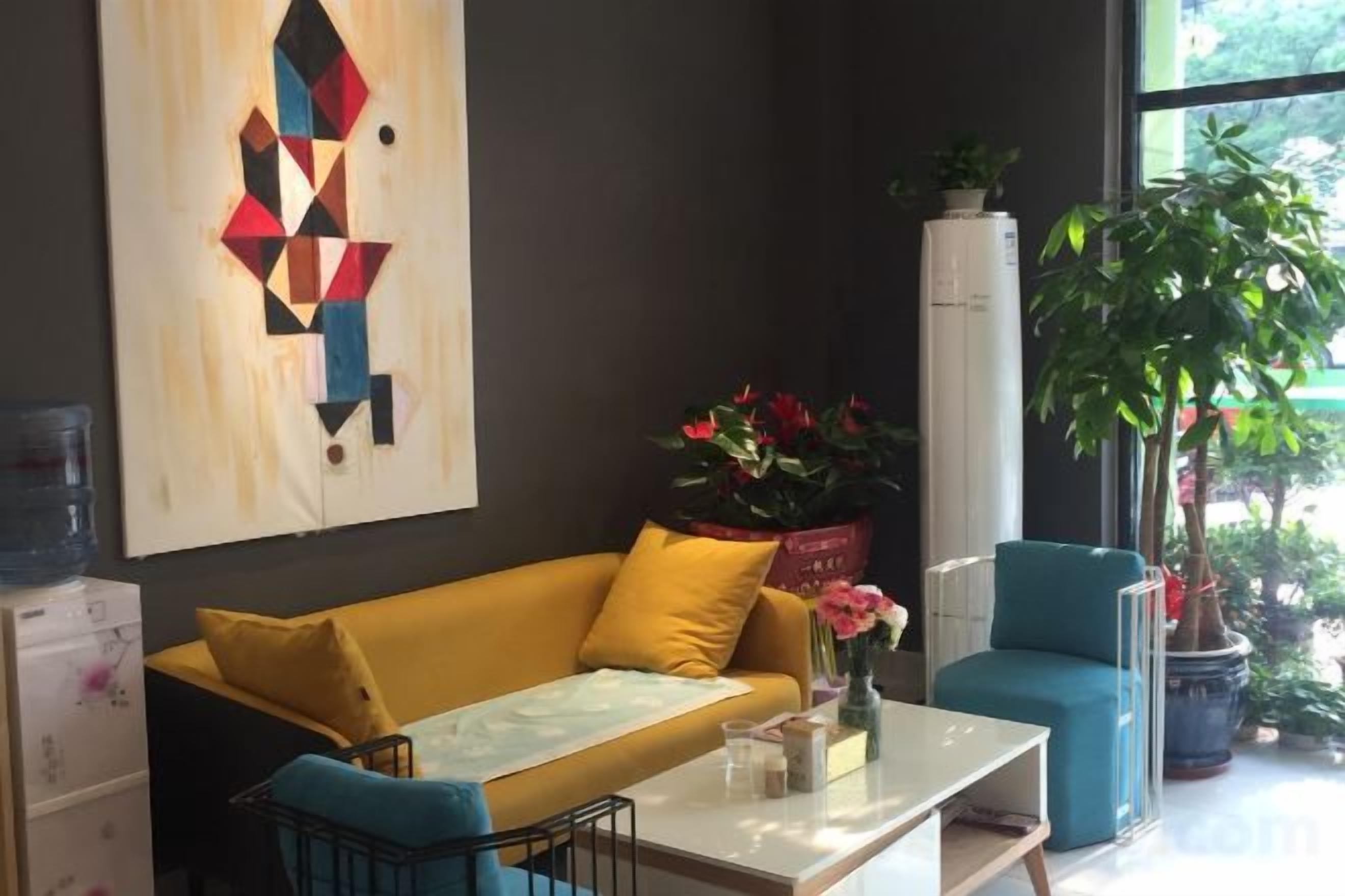 A modern living room with a sofa, a coffee table, and a potted plant.