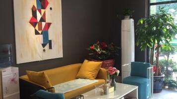 A modern living room with a sofa, a coffee table, and a potted plant.