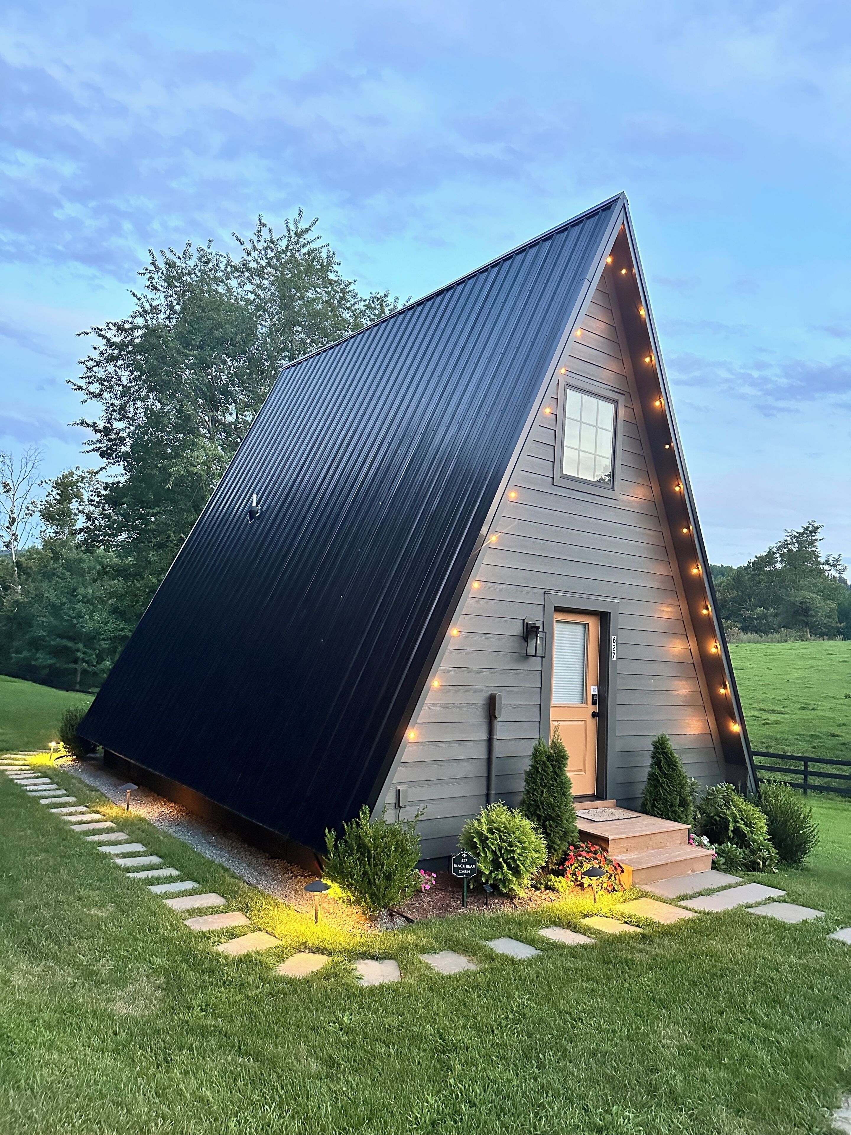 A small, modern house with a sloped roof, a front door, and a small window.