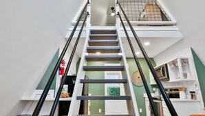 Un intérieur à plusieurs niveaux comprenant un escalier, un coin cuisine et un espace salon.