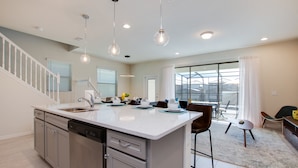 A modern kitchen with a central island, stainless steel appliances, and pendant lighting. - Beautiful Town Home with Splash Pool-8916SA (Kissimmee)