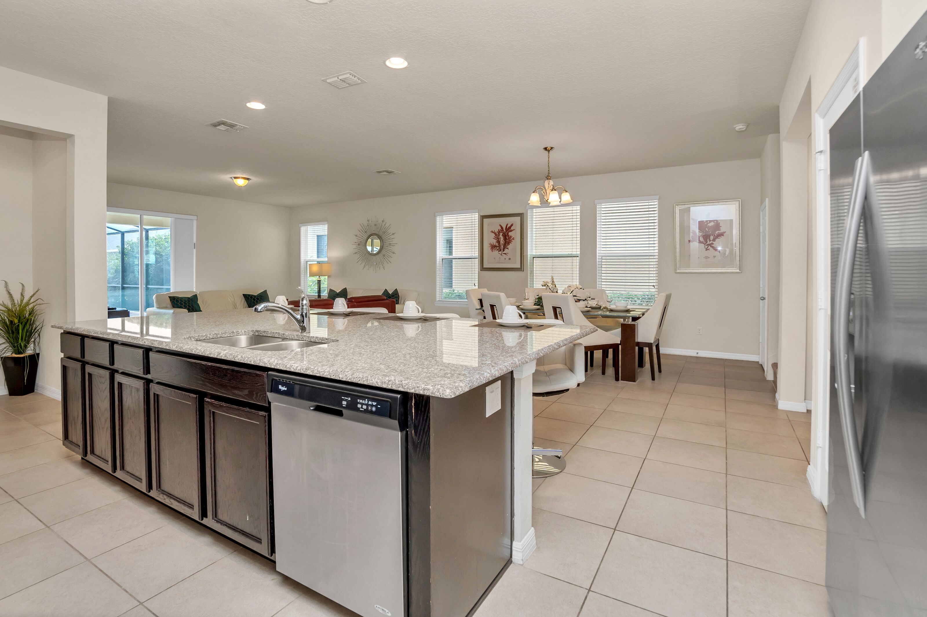 A modern kitchen with a central island, built-in dishwasher, and stainless steel appliances.