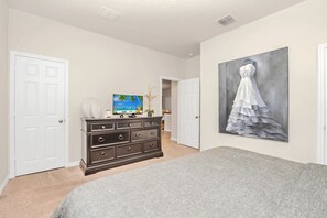 Une chambre à coucher avec un lit, une commode et des œuvres d’art.