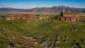 A large ranch-style house with multiple rooms, a covered patio, and a view of mountains in the background. - Experience Luxury in Nature: Private Lodge & Guest Home in Paradise Valley (Emigrant)