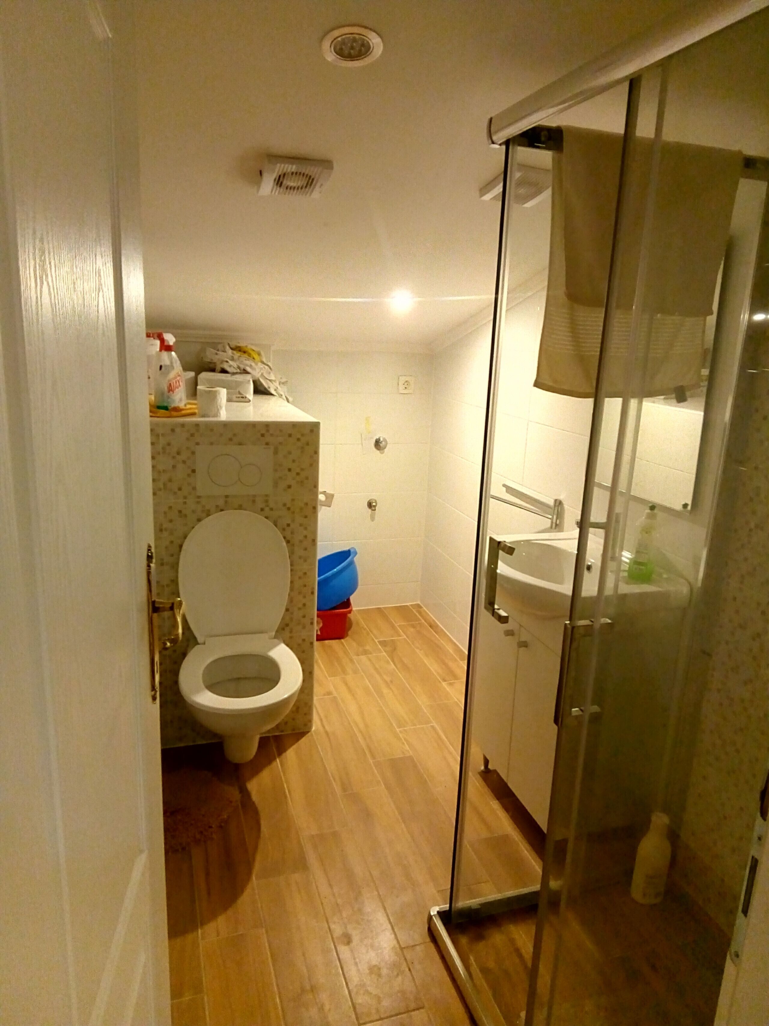 A bathroom with a toilet, a shower, and a sink.