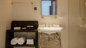 A bathroom with a white sink, a mirror, a towel rack, and a shelf with towels. - Cloud Inn River View hotel (Chongqing)