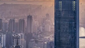 A high-rise building with a modern glass facade, surrounded by a dense urban skyline. - Cloud Inn River View hotel (Chongqing)