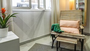 A corner room with a wooden chair, a small table, and a potted plant. - Sunflower Apartment by Hello Homes Sitges (Sitges)