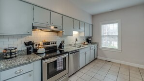 A modern kitchen with light blue cabinets, a stainless steel stove, and a dishwasher. - Chevy Chase-1mi to Rupp-Kroger Field-Downtown (Lexington)