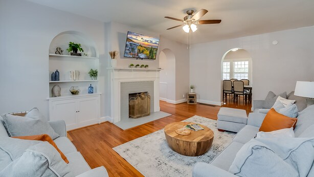 A living room with a fireplace, a ceiling fan, and a dining area with a table and chairs. - Chevy Chase-1mi to Rupp-Kroger Field-Downtown (Lexington)