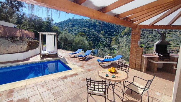 Un espace piscine comprenant un jacuzzi, des chaises longues et un barbecue.