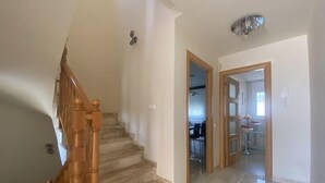 A staircase leading to a kitchen area with a dining table and chairs.