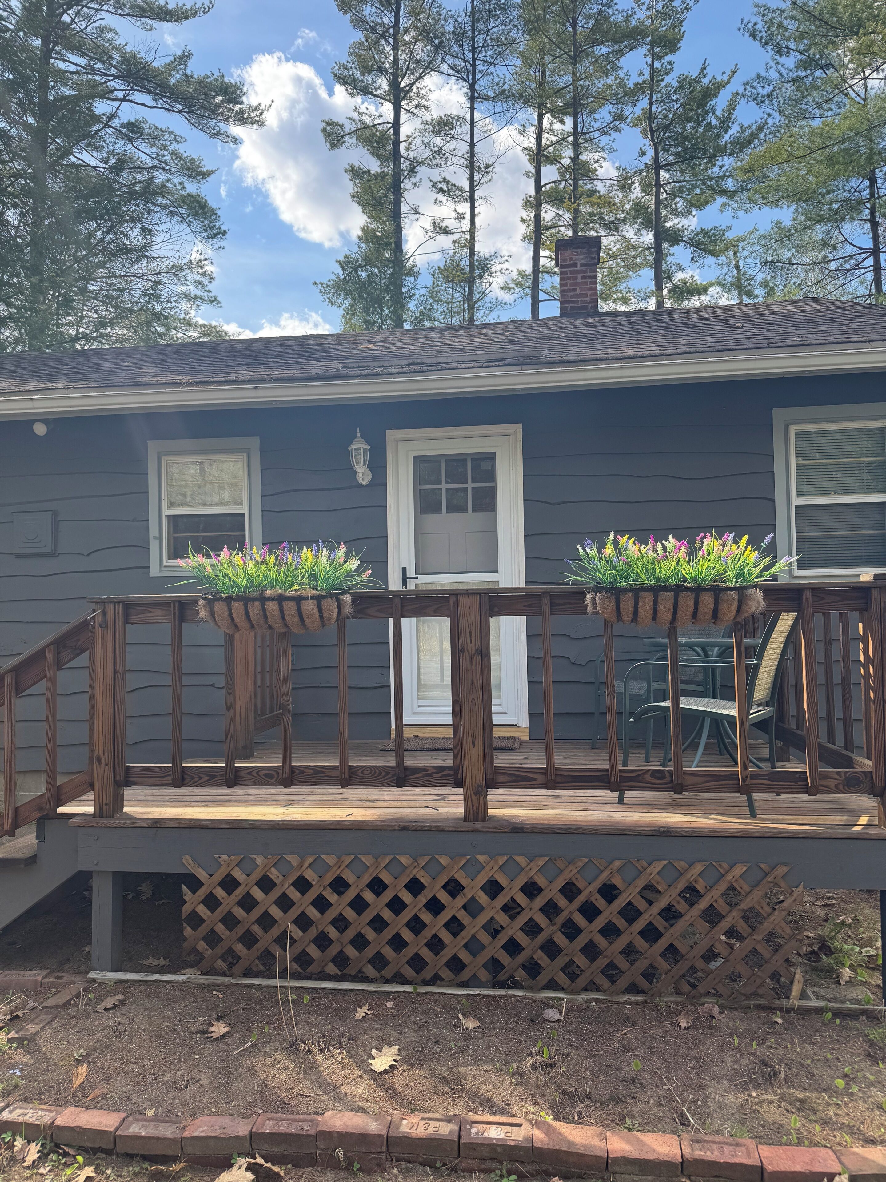 A house with a wooden deck, two windows, and a door.