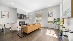 Een moderne woonkamer met een bank, een glazen salontafel en een open haard.