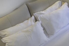 Un canapé beige avec des coussins blancs.