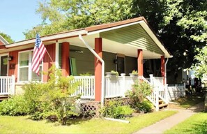 Welcome to this charming home with a cozy front porch, a small garden, and a white picket fence.