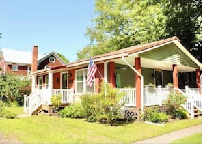 Traditional home with a charming front porch and beautifully manicured lawn.